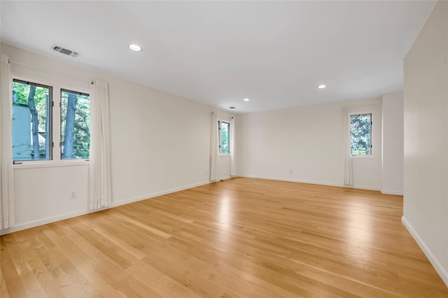 unfurnished room with light wood-style flooring, recessed lighting, and baseboards