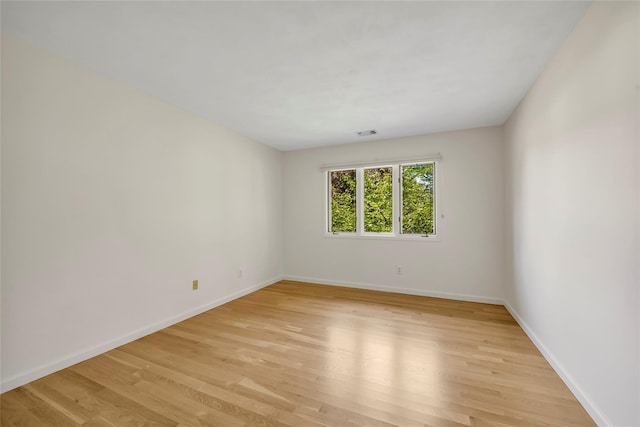 unfurnished room with light wood finished floors and baseboards