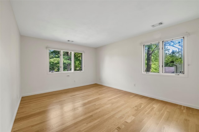 empty room with light wood finished floors and baseboards