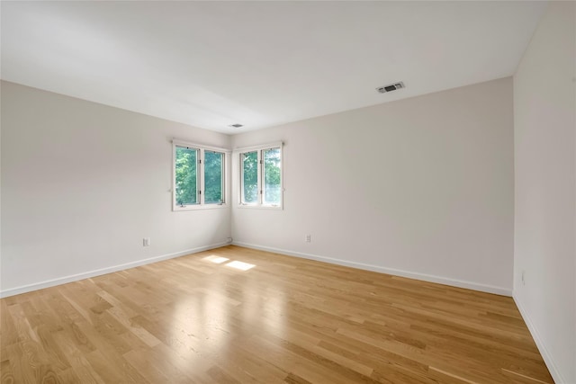 spare room featuring baseboards and light wood-type flooring