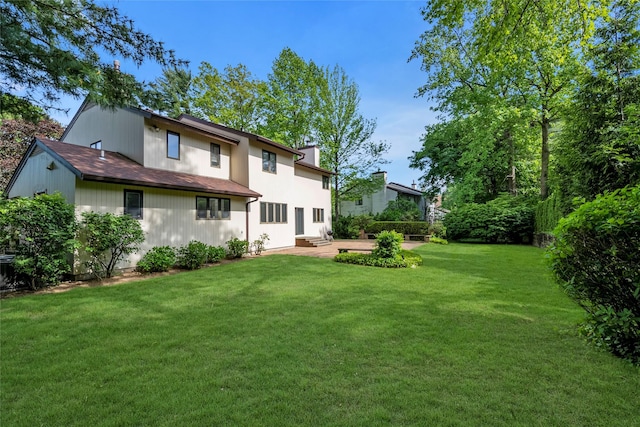 back of house featuring a lawn and a patio