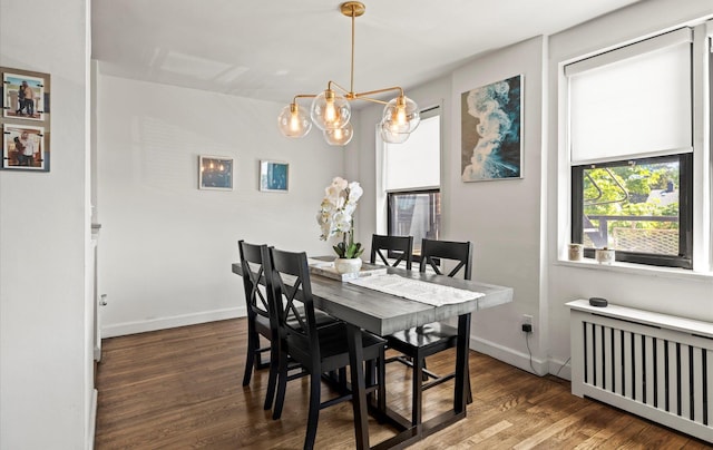 dining room featuring radiator heating unit, wood finished floors, a chandelier, and baseboards