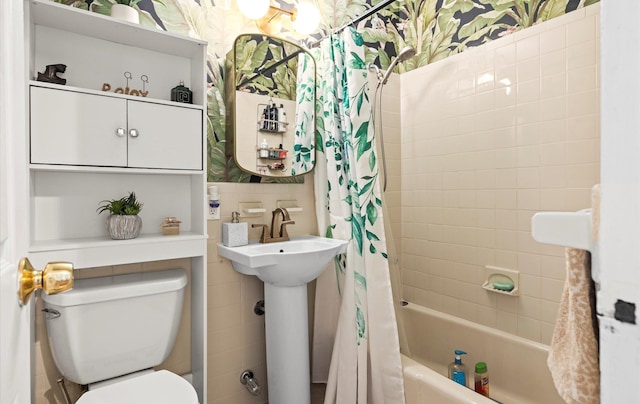 bathroom featuring shower / tub combo with curtain, toilet, and tile walls