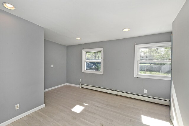 63 William St, Copiague, NY 11726 - spare room with baseboard heating, wood finished floors, recessed lighting, and baseboards