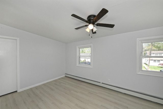 63 William St, Copiague, NY 11726 - spare room featuring a baseboard heating unit, plenty of natural light, and light wood-type flooring