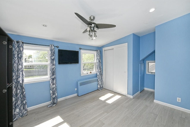 63 William St, Copiague, NY 11726 - unfurnished bedroom with radiator, multiple windows, wood finished floors, vaulted ceiling, and recessed lighting