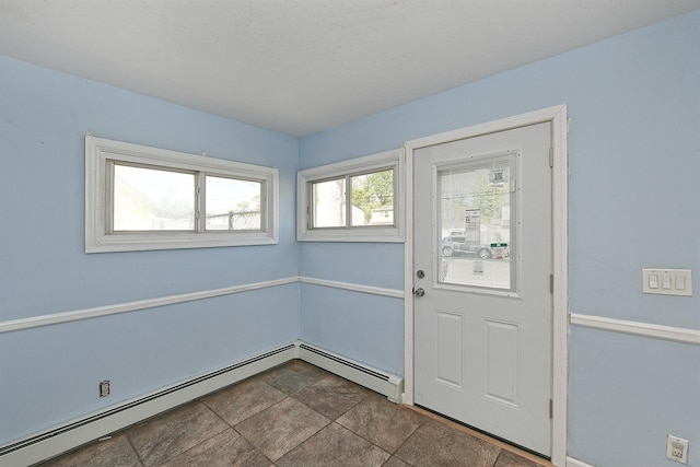 63 William St, Copiague, NY 11726 - doorway to outside with baseboard heating, stone finish floors, and baseboards