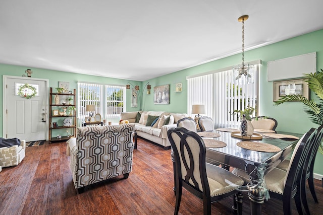 dining area with dark wood-style floors and a chandelier