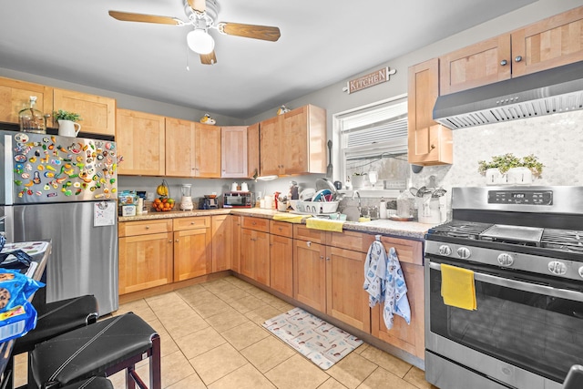 kitchen featuring stainless steel appliances, under cabinet range hood, a ceiling fan, a sink, and light tile patterned floors