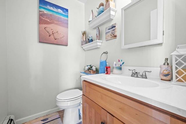 bathroom with toilet, vanity, and a baseboard radiator