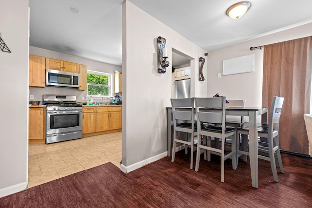 dining room featuring baseboards and light wood-style floors