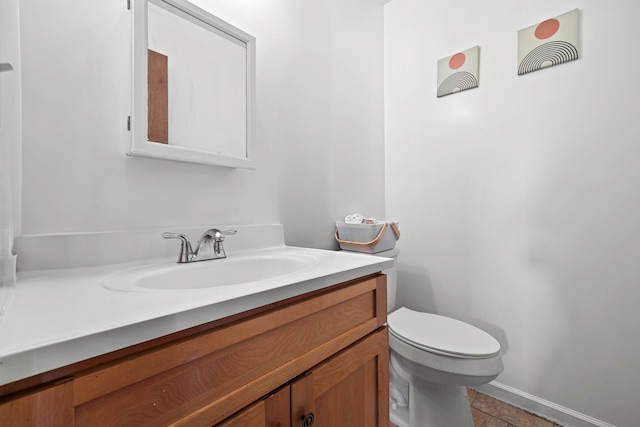 bathroom with vanity, toilet, tile patterned flooring, and baseboards