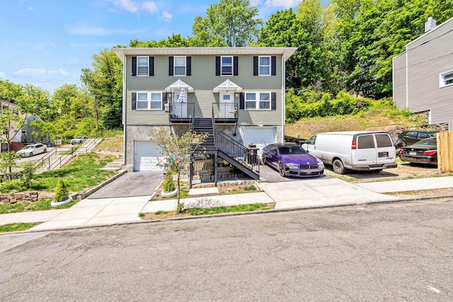 townhome / multi-family property featuring stairs, an attached garage, and concrete driveway