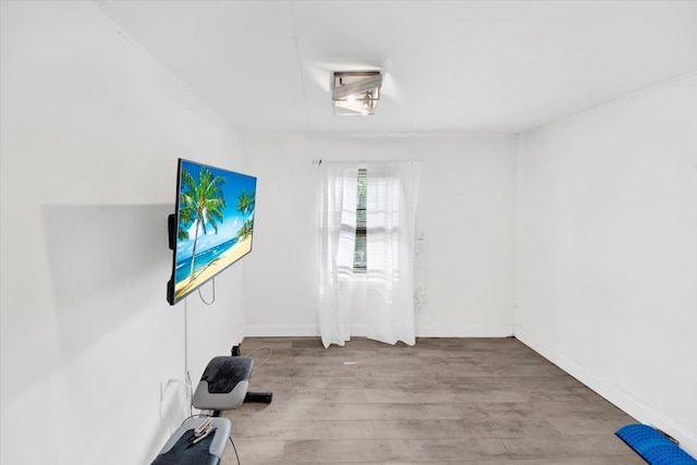 workout area featuring wood finished floors and baseboards