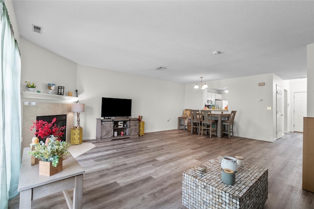 37 Spruce St, Pawling, NY 12564 - living room featuring wood finished floors, a tile fireplace, a chandelier, and baseboards