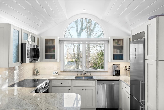 67 N Rd Unit A, Hampton Bays, NY 11946 - kitchen with appliances with stainless steel finishes, a sink, lofted ceiling, plenty of natural light, and light stone countertops