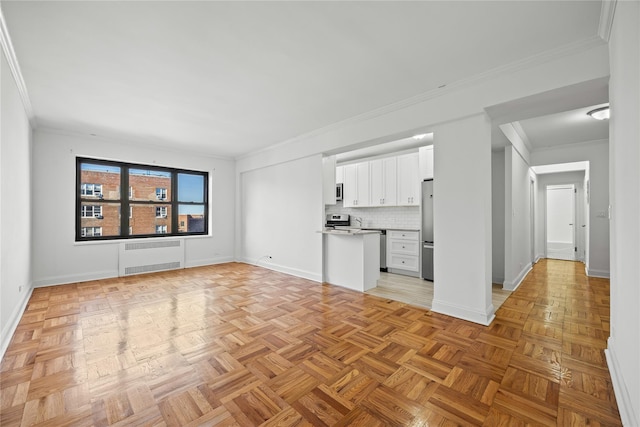 unfurnished living room featuring radiator heating unit, ornamental molding, and baseboards