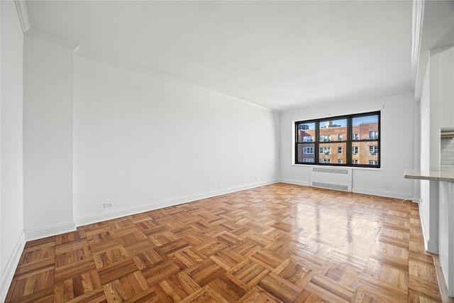 empty room with radiator, crown molding, and baseboards