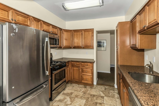 14 Florence Unit 25D, Freeport, NY 11520 - kitchen with appliances with stainless steel finishes, brown cabinetry, a sink, and stone finish floors