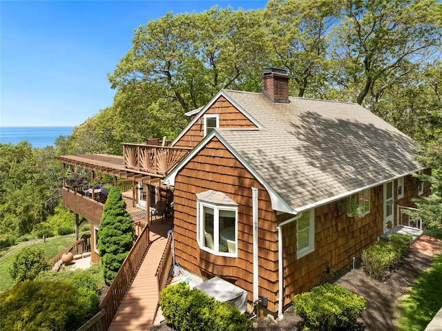 3 Summit Dr, Baiting Hollow, NY 11933 - view of home's exterior featuring a chimney, a shingled roof, and a deck with water view