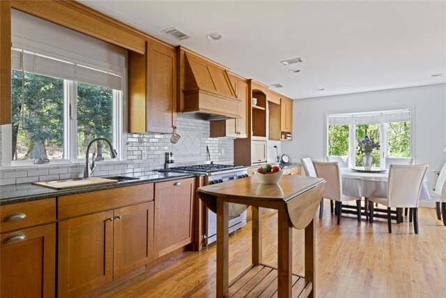 3 Summit Dr, Baiting Hollow, NY 11933 - kitchen featuring stainless steel range with gas cooktop, custom exhaust hood, a sink, decorative backsplash, and dark countertops