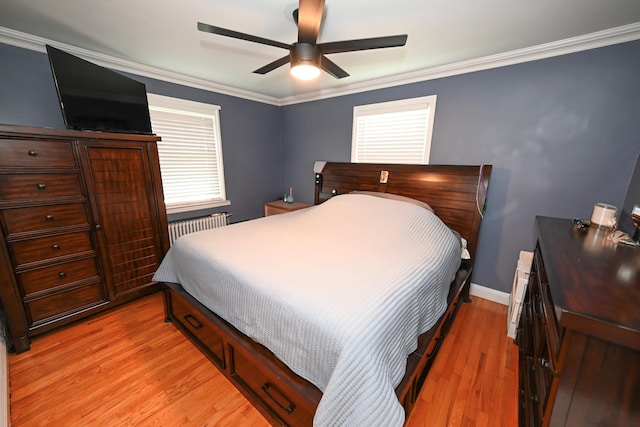 bedroom featuring radiator heating unit, multiple windows, light wood-style flooring, crown molding, and ceiling fan