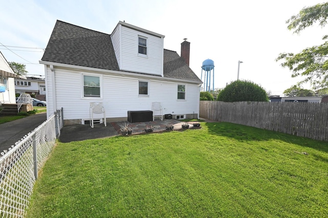 back of property with roof with shingles, a patio area, and a chimney