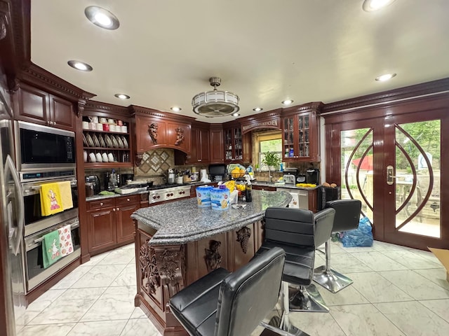 20-42 26th St, Astoria, NY 11105 - kitchen with light marble finish floors, recessed lighting, black microwave, decorative backsplash, and glass insert cabinets