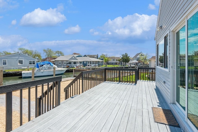 wooden deck featuring a residential view and a water view