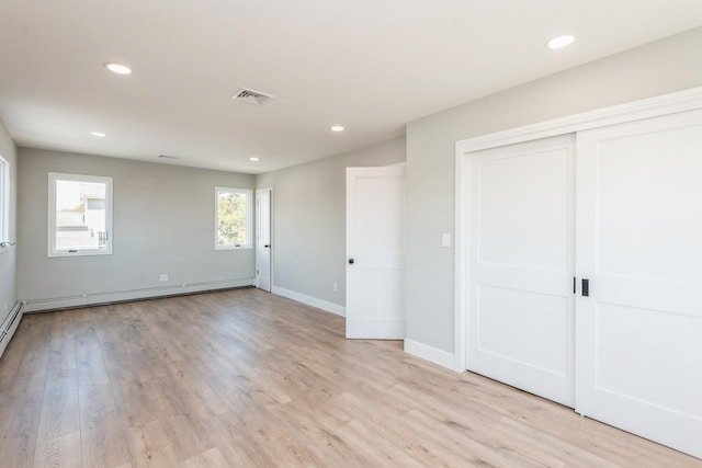 unfurnished bedroom with recessed lighting, light wood finished floors, baseboards, and a closet