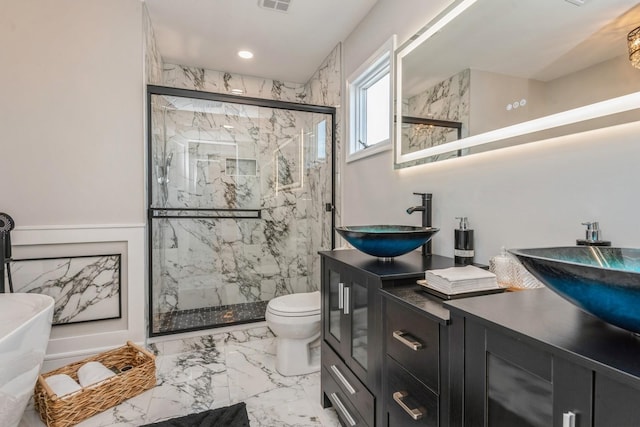 bathroom featuring marble finish flooring, a marble finish shower, toilet, double vanity, and recessed lighting