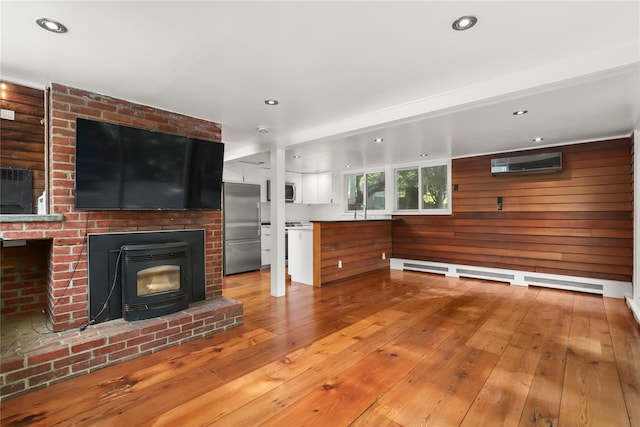 14 Lounsbury Rd, Croton-On-Hudson, NY 10520 - unfurnished living room featuring a wall unit AC, wood-type flooring, a sink, recessed lighting, and wooden walls