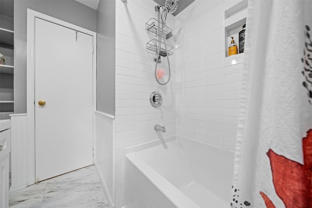 bathroom featuring marble finish floors and shower / bath combo with shower curtain