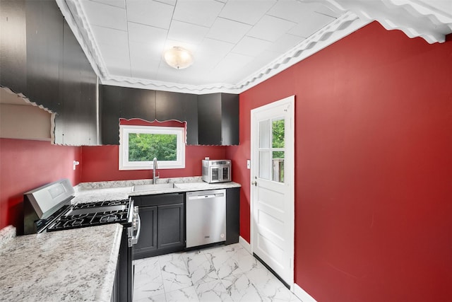 kitchen with stainless steel appliances, a sink, plenty of natural light, and light countertops
