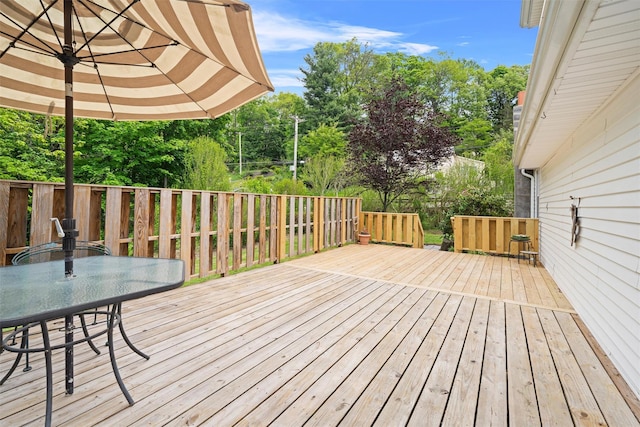 deck featuring outdoor dining space and view of scattered trees