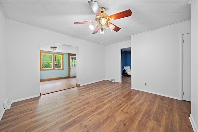 spare room featuring ceiling fan, wood finished floors, ornamental molding, and baseboards