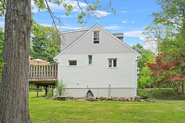 view of side of home featuring a lawn and a deck