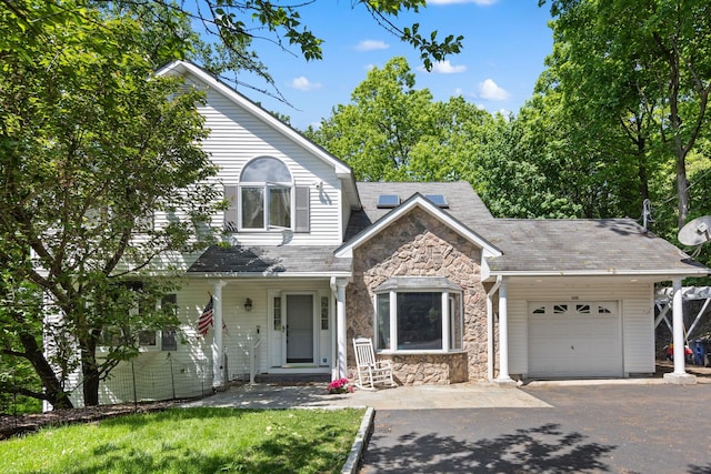 11C Piping Rock Dr, Ossining, NY 10562 - view of front of house featuring stone siding, a garage, driveway, and roof with shingles