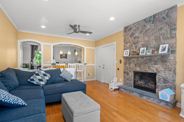 11C Piping Rock Dr, Ossining, NY 10562 - living area featuring a stone fireplace, arched walkways, crown molding, wood finished floors, and ceiling fan