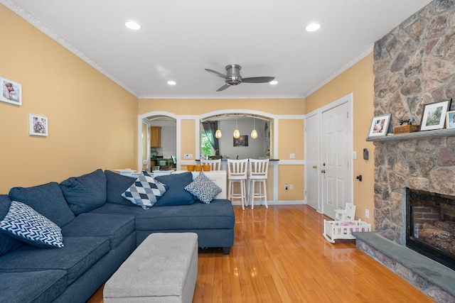11C Piping Rock Dr, Ossining, NY 10562 - living room featuring a fireplace, arched walkways, ornamental molding, light wood finished floors, and ceiling fan