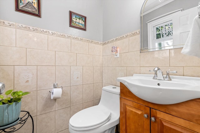bathroom with tile walls, toilet, and vanity