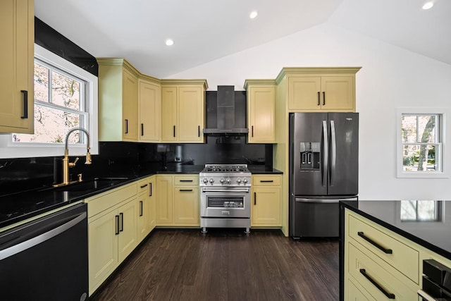 10 Shinnecock Ln, Hampton Bays, NY 11946 - kitchen featuring stainless steel appliances, wall chimney exhaust hood, cream cabinetry, vaulted ceiling, and a sink