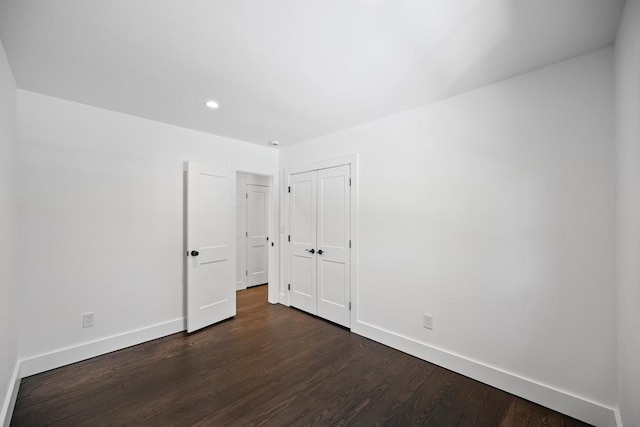 10 Shinnecock Ln, Hampton Bays, NY 11946 - unfurnished bedroom with baseboards, dark wood-style floors, recessed lighting, and a closet