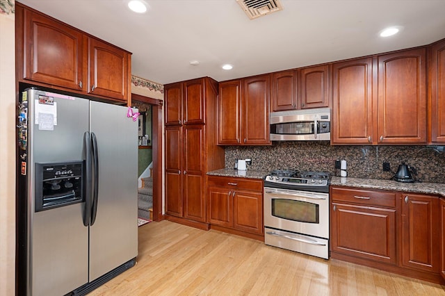 251 N Idaho Ave, Massapequa, NY 11758 - kitchen with stainless steel appliances, light wood-type flooring, dark stone countertops, tasteful backsplash, and recessed lighting