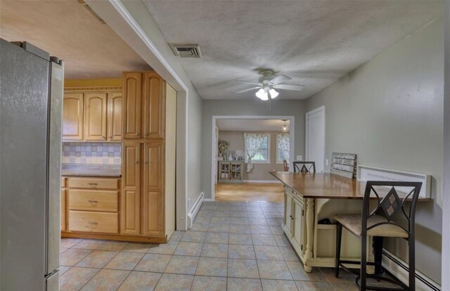 1547 Rte 208, Washingtonville, NY 10992 - kitchen featuring freestanding refrigerator, ceiling fan, decorative backsplash, light tile patterned floors, and baseboard heating