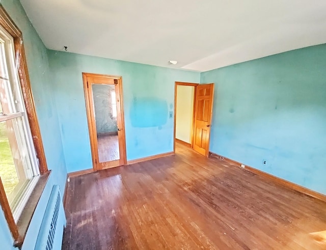 233 Peaceable Hill Rd, Brewster, NY 10509 - spare room with wood finished floors, baseboards, and a wall unit AC