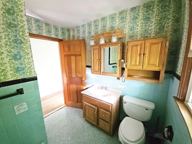233 Peaceable Hill Rd, Brewster, NY 10509 - bathroom featuring wallpapered walls, tile walls, a wainscoted wall, toilet, and vanity