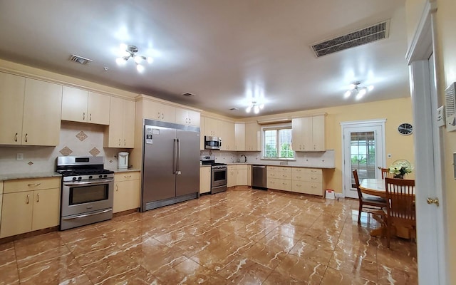 8 Lemberg Ct Unit 302, Monroe, NY 10950 - kitchen with stainless steel appliances, cream cabinets, backsplash, light countertops, and marble finish flooring