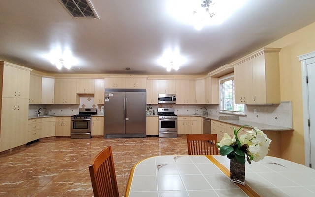 8 Lemberg Ct Unit 302, Monroe, NY 10950 - kitchen with appliances with stainless steel finishes, a sink, decorative backsplash, and cream cabinetry
