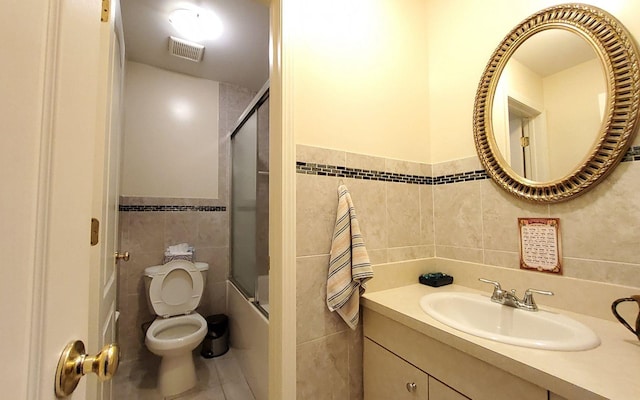 8 Lemberg Ct Unit 302, Monroe, NY 10950 - full bath with tile walls, toilet, tile patterned flooring, vanity, and bath / shower combo with glass door